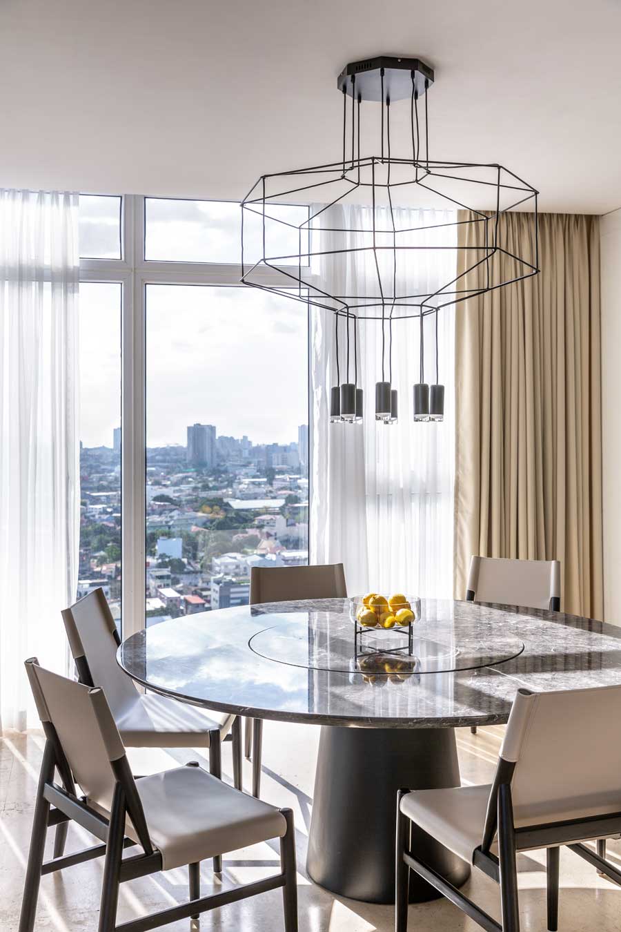 Dining room interior design featuring the built in wood tv cabinet with white and chrome elements in the Twelve Luxury Flats, San Juan Manila