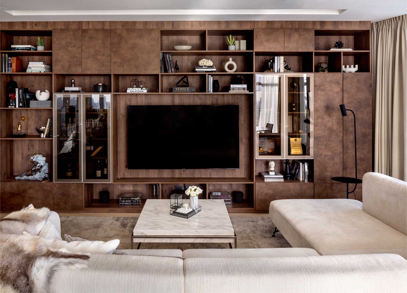 Living room interior design featuring the built in wood tv cabinet with white and chrome elements in the Twelve Luxury Flats, San Juan Manila