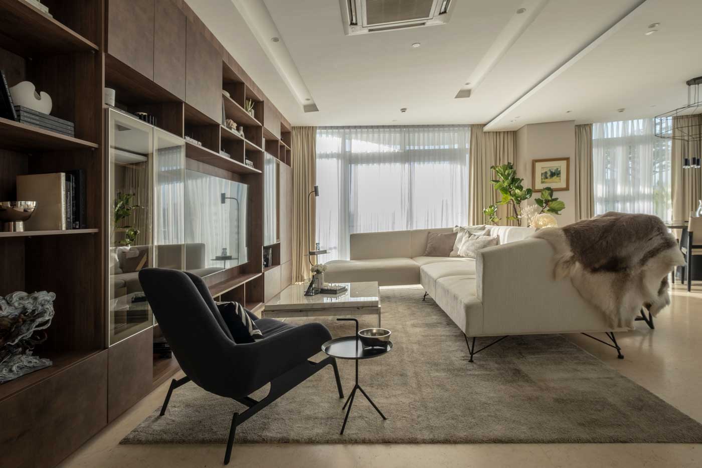 Living room interior design featuring the built in wood tv cabinet with white and chrome elements in the Twelve Luxury Flats, San Juan Manila