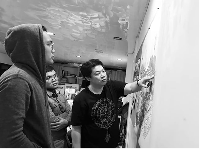 Architect William Ti pointing at the design plans on the board