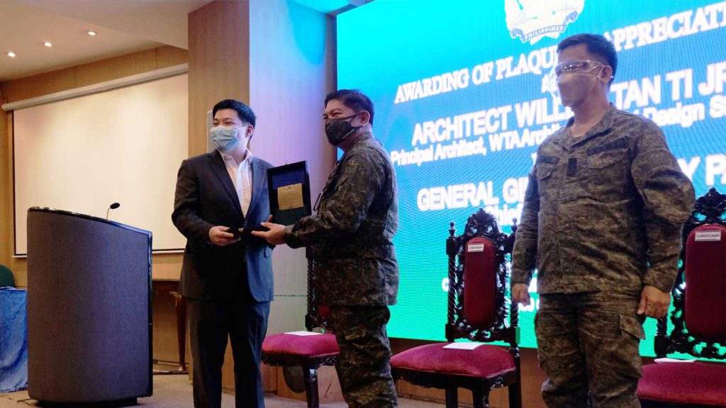 PARTNERS IN COVID-19 RESPONSE. William Tan Ti Jr. (left), the principal architect of WTA Architecture and Design Studio, receives a plaque of appreciation from AFP Chief of Staff, Gen. Gilbert Gapay (center), in a ceremony in Camp Aguinaldo, Quezon City on Wednesday (Oct. 28, 2020). The WTA Architecture and Design Studio was the lead company that designed and initiated the construction of emergency quarantine facilities in military and government health institutions in response to the Covid-19 outbreak. (Photo courtesy of the AFP Public Affairs Office)